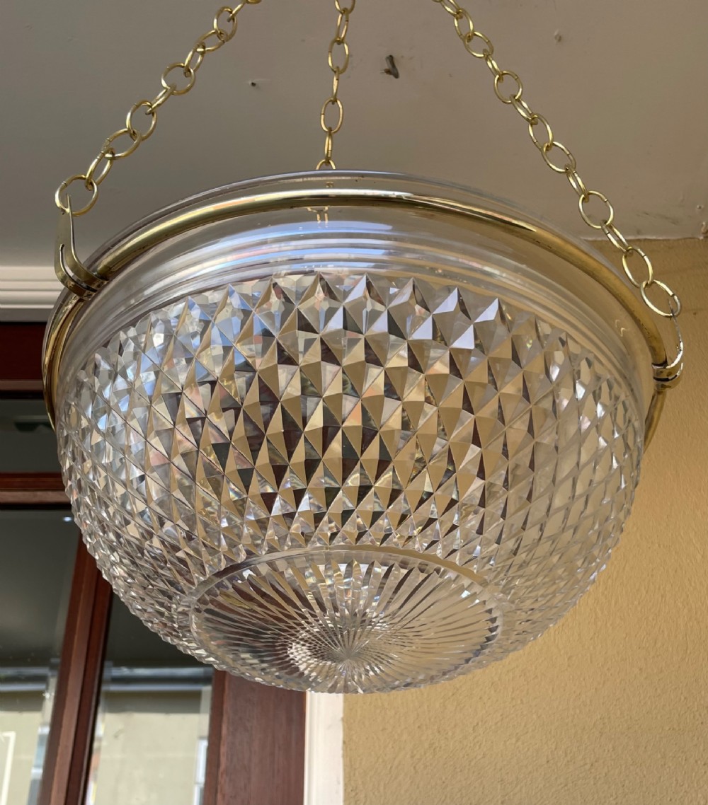 An Edwardian period cut glass bowl light shade suspended by three brass link chains connected to a central brass rim. View V