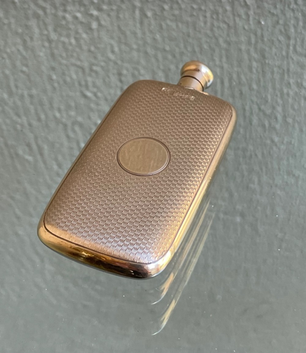 A small rectangular 9ct yellow gold scent flask featuring fine engine-turned geometric detailing, a central circular cartouche, and a screw top. View II