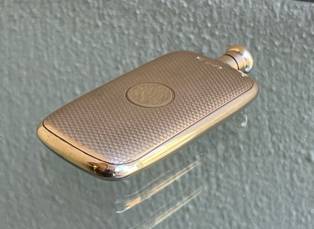 A small rectangular 9ct yellow gold scent flask featuring fine engine-turned geometric detailing, a central circular cartouche, and a screw top. View IV