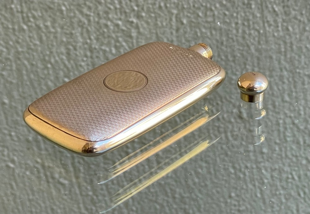 A small rectangular 9ct yellow gold scent flask featuring fine engine-turned geometric detailing, a central circular cartouche, and a screw top. View VII