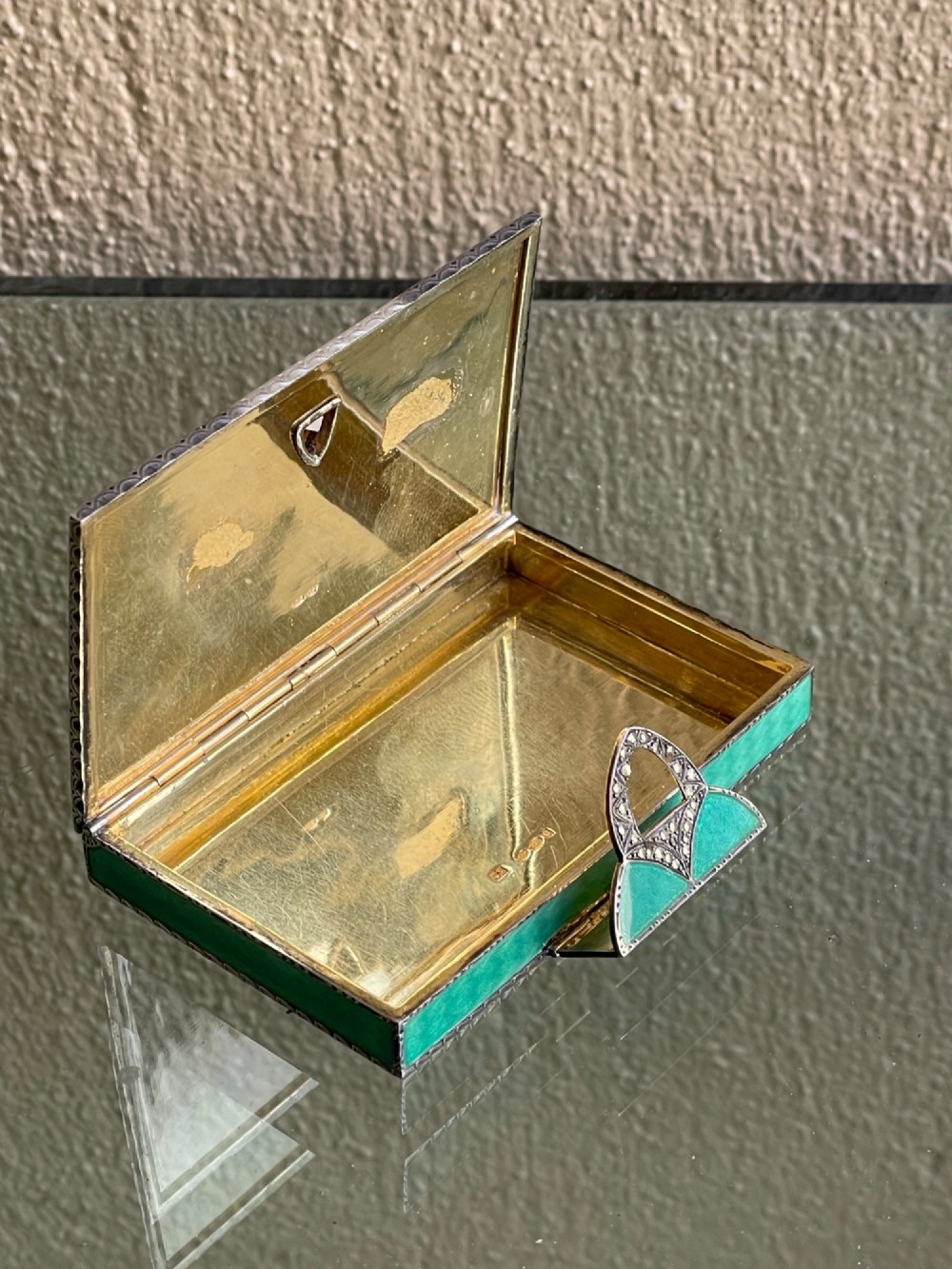 An Art Deco rectangular silver card case featuring turquoise sunburst guilloche enamel and a triangular gemstone clasp. View IX