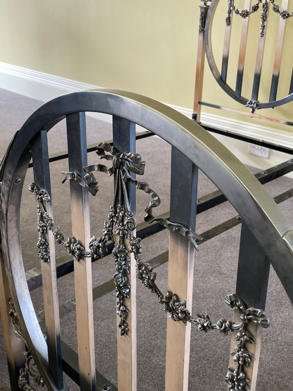 A matching pair of Art Nouveau nickel-plated single bed frames with circular slatted panels and cast ribbon swags. View III