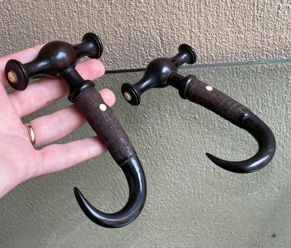 A pair of Victorian boot pulls featuring turned dark handles with bone inlays and curved horn hooks. View II