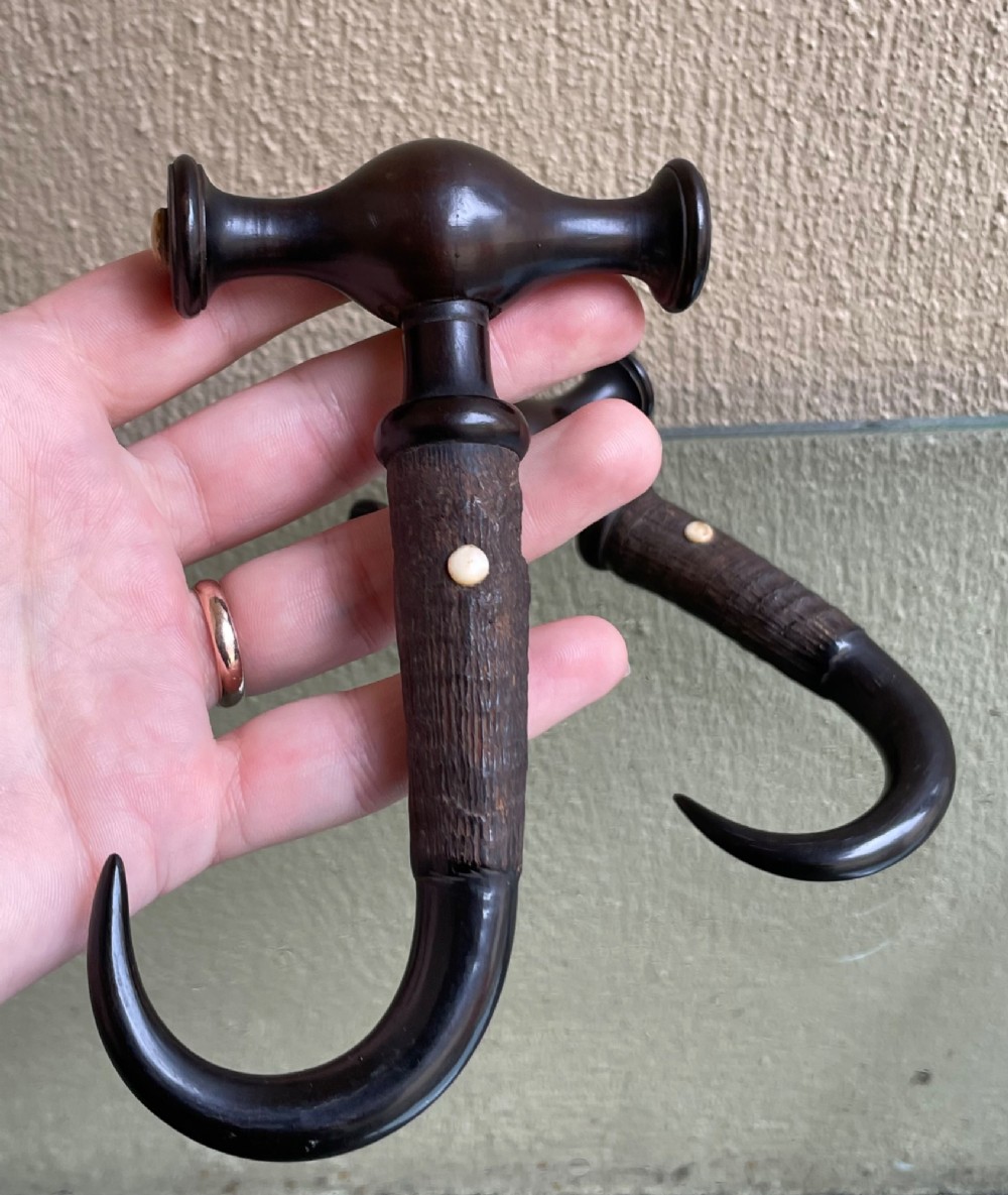 A pair of Victorian boot pulls featuring turned dark handles with bone inlays and curved horn hooks. View III