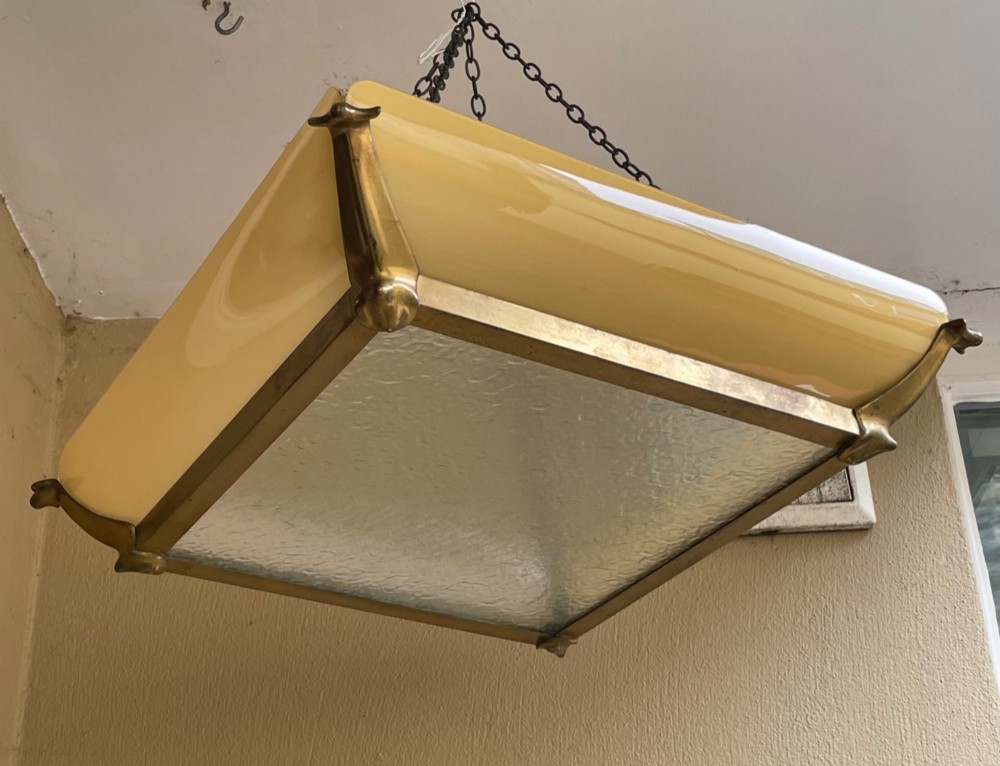 An Art Deco square pendant ceiling light featuring yellow glass side panels set within a brass frame, suspended by dark metal chains. View II