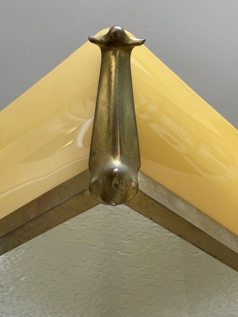 An Art Deco square pendant ceiling light featuring yellow glass side panels set within a brass frame, suspended by dark metal chains. View V