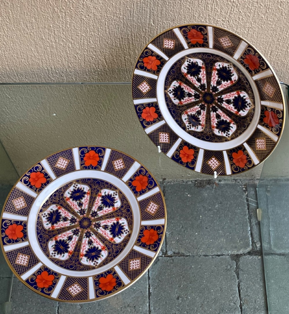 A pair of circular fine bone china plates decorated in an intricate Imari pattern with cobalt blue, iron red floral motifs, and detailed gold gilding. View II