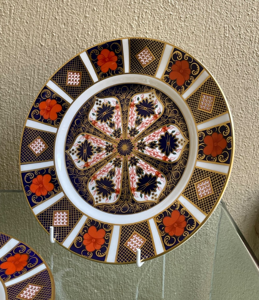 A pair of circular fine bone china plates decorated in an intricate Imari pattern with cobalt blue, iron red floral motifs, and detailed gold gilding. View III