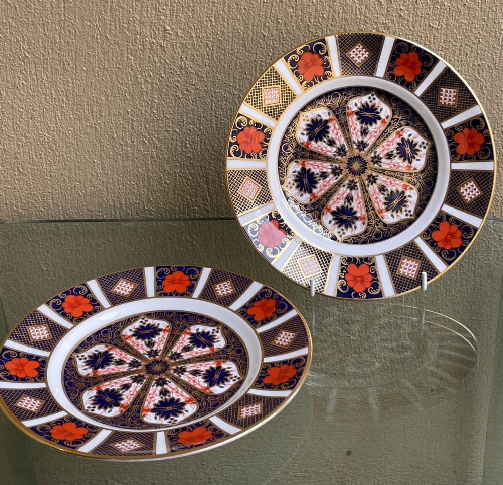 A pair of circular fine bone china plates decorated in an intricate Imari pattern with cobalt blue, iron red floral motifs, and detailed gold gilding. View IV