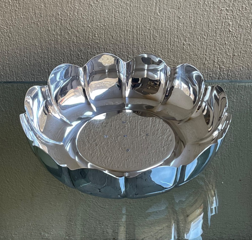 A circular solid silver strawberry dish featuring fluted lobed edges and hallmarks stamped in the flat central well. View II