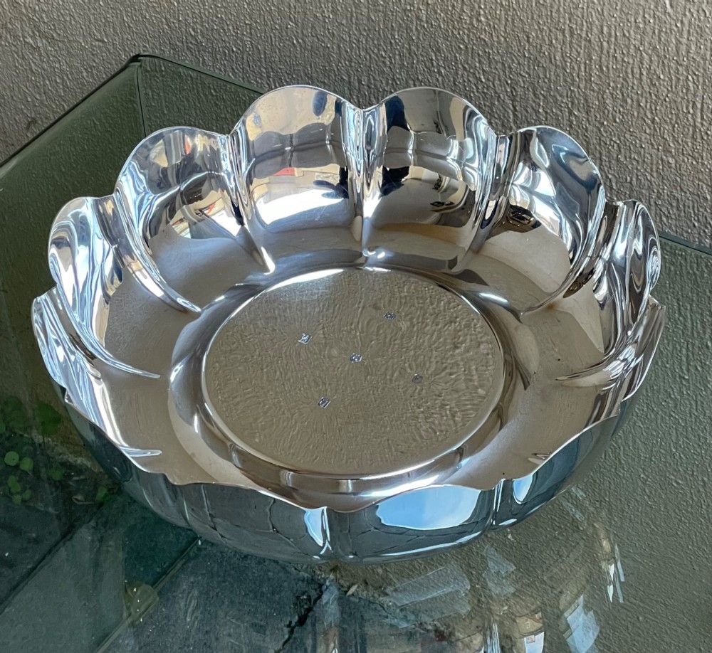 A circular solid silver strawberry dish featuring fluted lobed edges and hallmarks stamped in the flat central well. View III