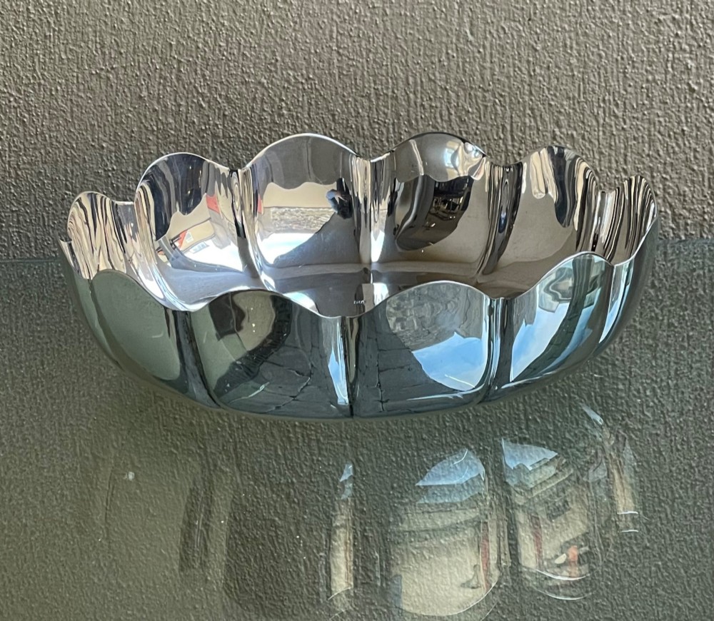 A circular solid silver strawberry dish featuring fluted lobed edges and hallmarks stamped in the flat central well. View V