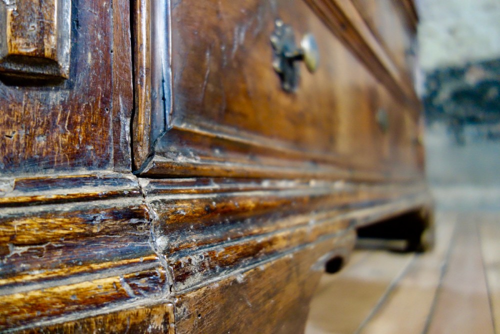 A large seventeenth-century North Italian walnut commode featuring four moulded drawers with brass knobs and key escutcheons. View II