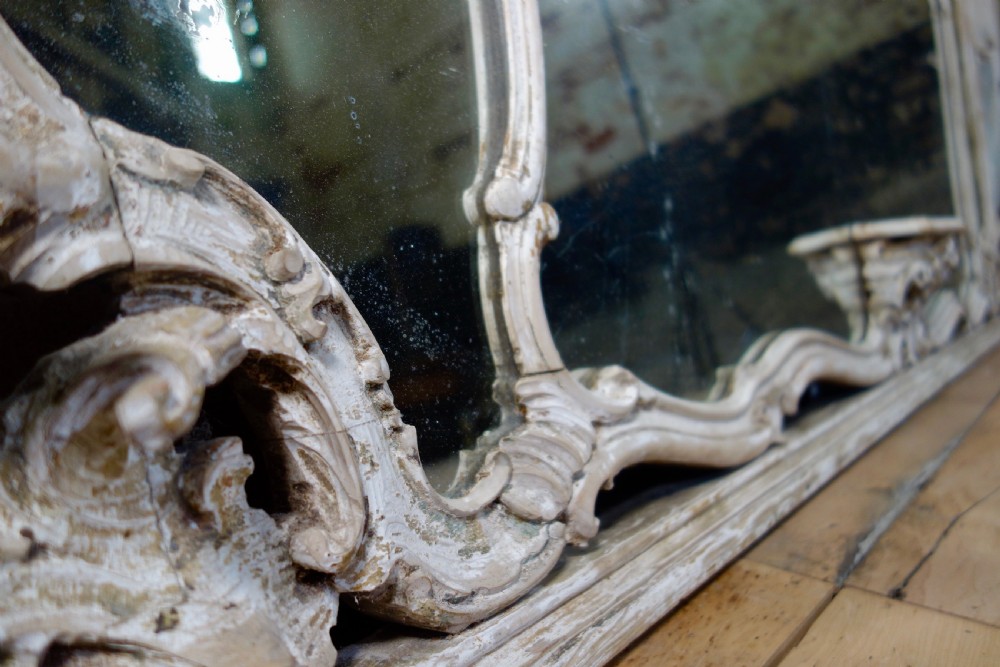 An expansive 19th-century French Rococo wall mirror featuring a carved off-white serpentine frame decorated with ornate acanthus scrolls and cresting. View II