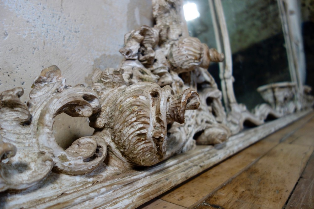 An expansive 19th-century French Rococo wall mirror featuring a carved off-white serpentine frame decorated with ornate acanthus scrolls and cresting. View III