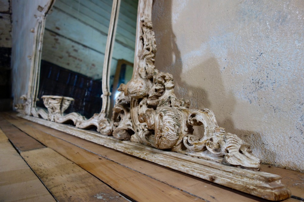 An expansive 19th-century French Rococo wall mirror featuring a carved off-white serpentine frame decorated with ornate acanthus scrolls and cresting. View XII