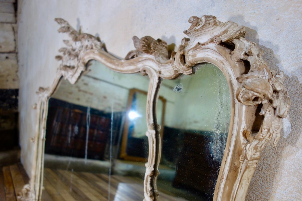 An expansive 19th-century French Rococo wall mirror featuring a carved off-white serpentine frame decorated with ornate acanthus scrolls and cresting. View XV