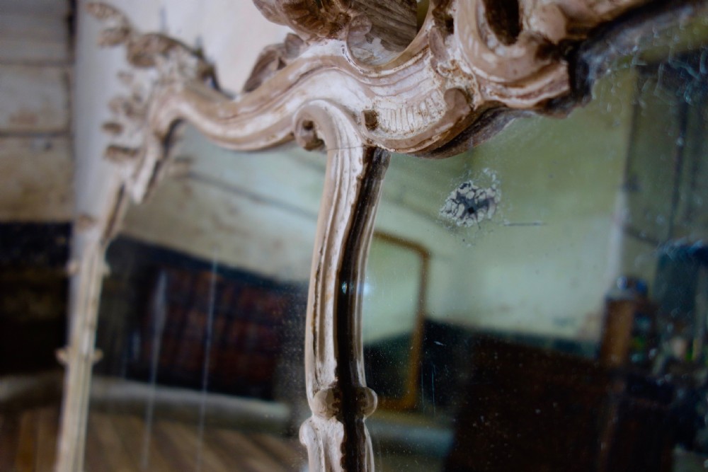 An expansive 19th-century French Rococo wall mirror featuring a carved off-white serpentine frame decorated with ornate acanthus scrolls and cresting. View XVI