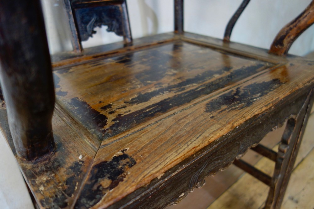 A 19th-century dark elm Chinese officials hat armchair featuring a carved yoke-back crest rail and pierced splat. View II