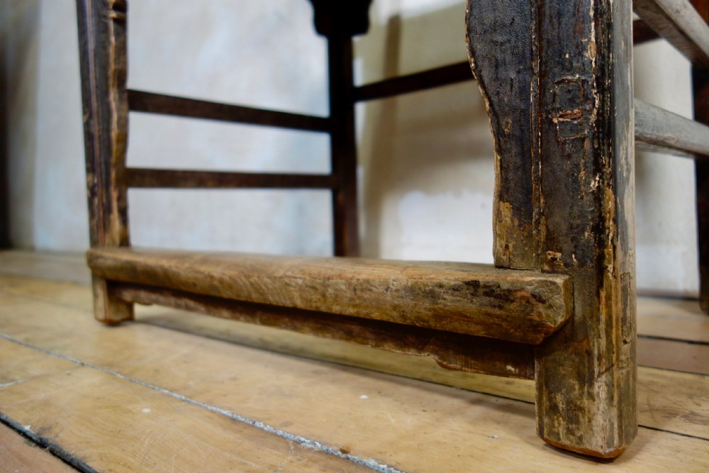 A 19th-century dark elm Chinese officials hat armchair featuring a carved yoke-back crest rail and pierced splat. View VII