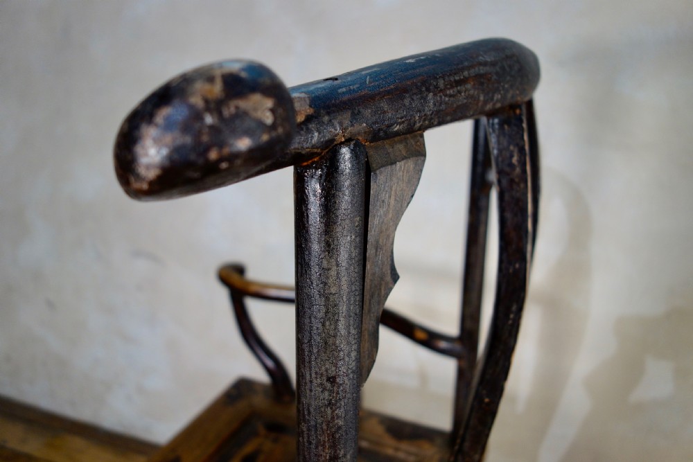 A 19th-century dark elm Chinese officials hat armchair featuring a carved yoke-back crest rail and pierced splat. View X