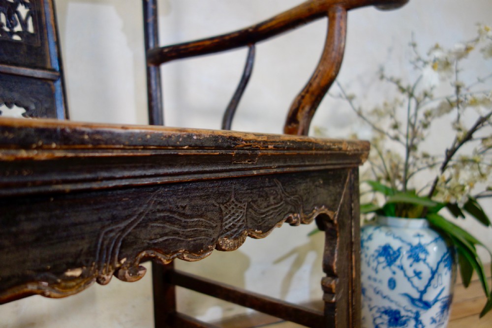 A 19th-century dark elm Chinese officials hat armchair featuring a carved yoke-back crest rail and pierced splat. View XV