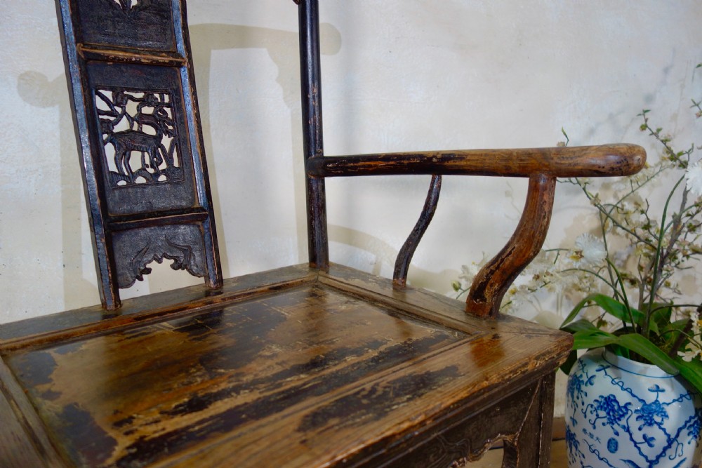 A 19th-century dark elm Chinese officials hat armchair featuring a carved yoke-back crest rail and pierced splat. View XVI