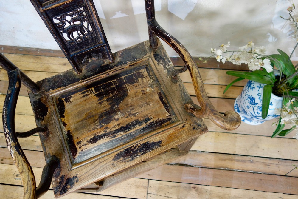 A 19th-century dark elm Chinese officials hat armchair featuring a carved yoke-back crest rail and pierced splat. View XVII