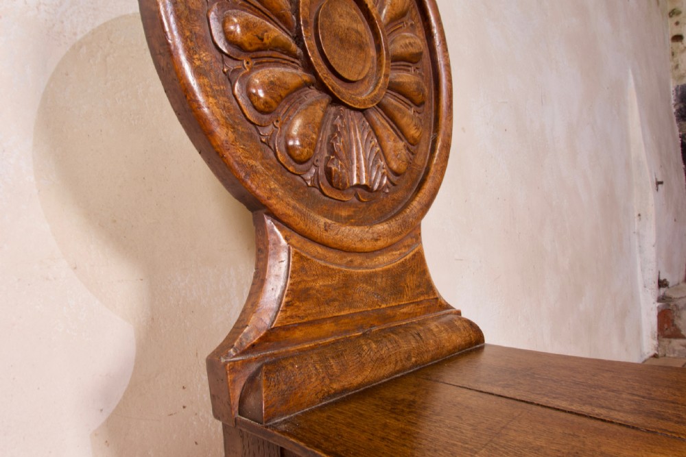 A 19th-century William IV hall chair made from elm and burr elm featuring a carved circular medallion back, solid wooden seat, turned front legs, and curved rear legs. View VI