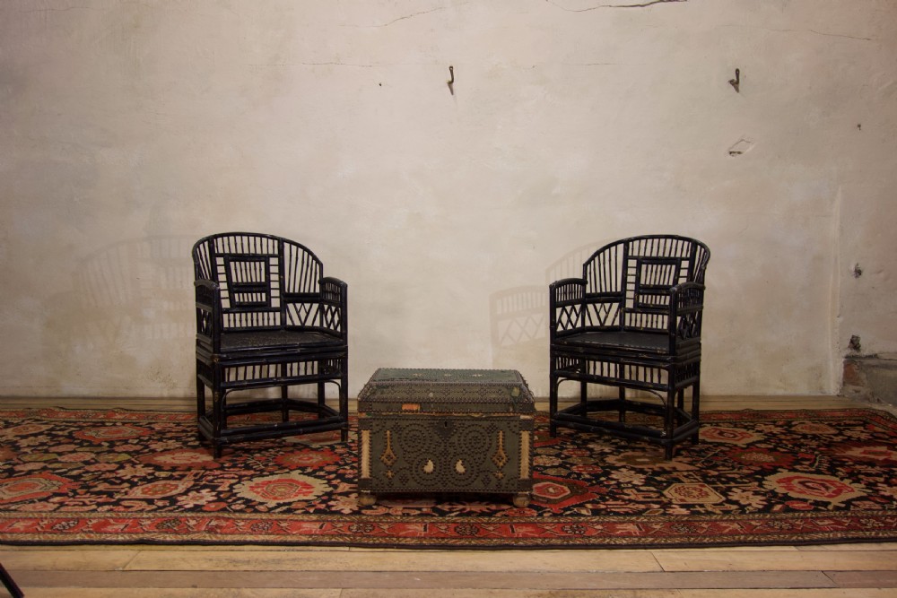 A small 19th-century French trunk featuring olive green fabric, brass stud patterning, iron side handles, and wooden bun feet. View II