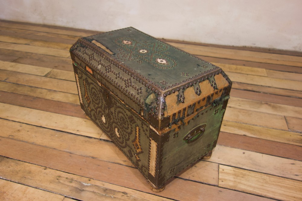 A small 19th-century French trunk featuring olive green fabric, brass stud patterning, iron side handles, and wooden bun feet. View XIII