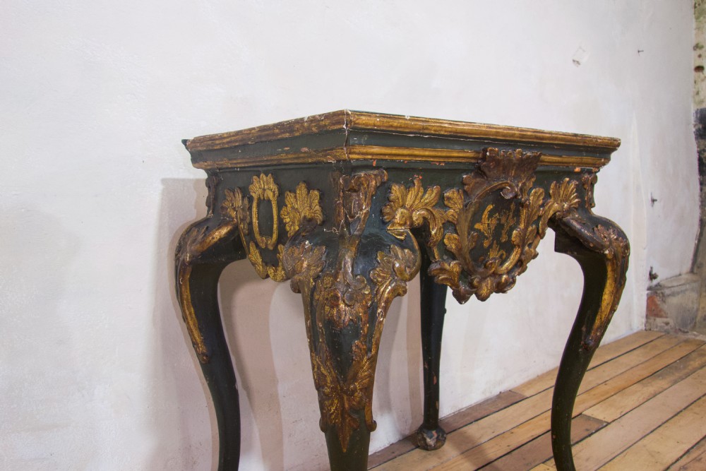 An 18th-century Italian Baroque console table featuring a marble top, a dark painted frame with gilded acanthus leaf carvings, and cabriole legs. View II