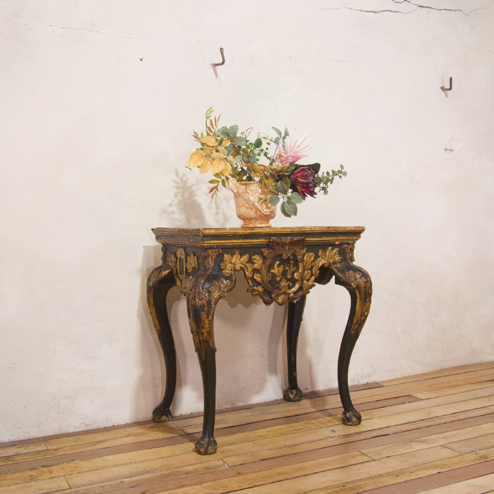 An 18th-century Italian Baroque console table featuring a marble top, a dark painted frame with gilded acanthus leaf carvings, and cabriole legs. View VI