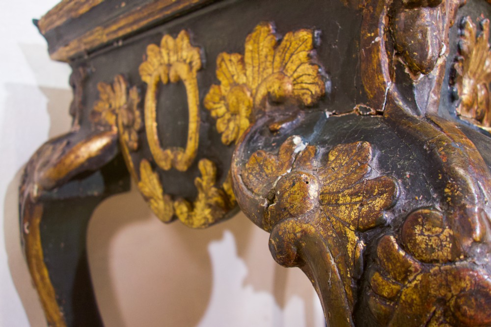 An 18th-century Italian Baroque console table featuring a marble top, a dark painted frame with gilded acanthus leaf carvings, and cabriole legs. View VIII
