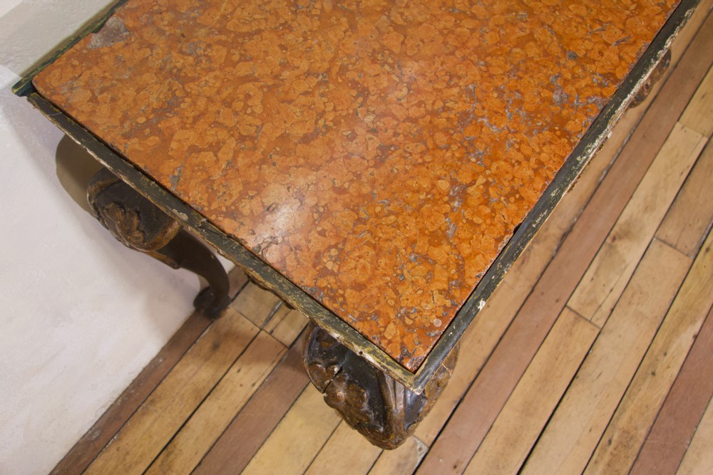An 18th-century Italian Baroque console table featuring a marble top, a dark painted frame with gilded acanthus leaf carvings, and cabriole legs. View XII