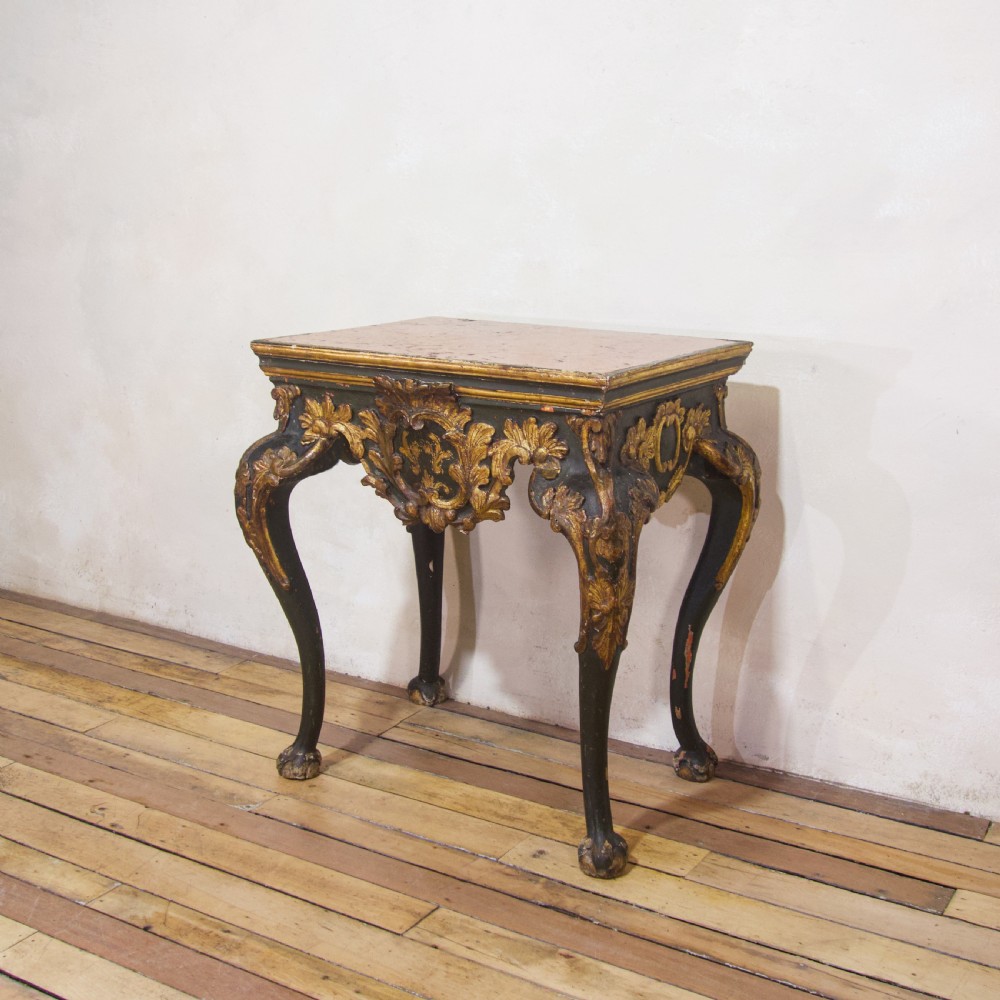 An 18th-century Italian Baroque console table featuring a marble top, a dark painted frame with gilded acanthus leaf carvings, and cabriole legs. View XIV