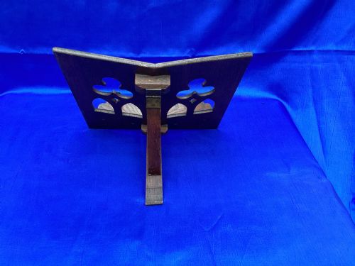 fig 1. A dark carved oak desktop book stand featuring openwork Gothic lancet arches and trefoil tracery with brass page clips.