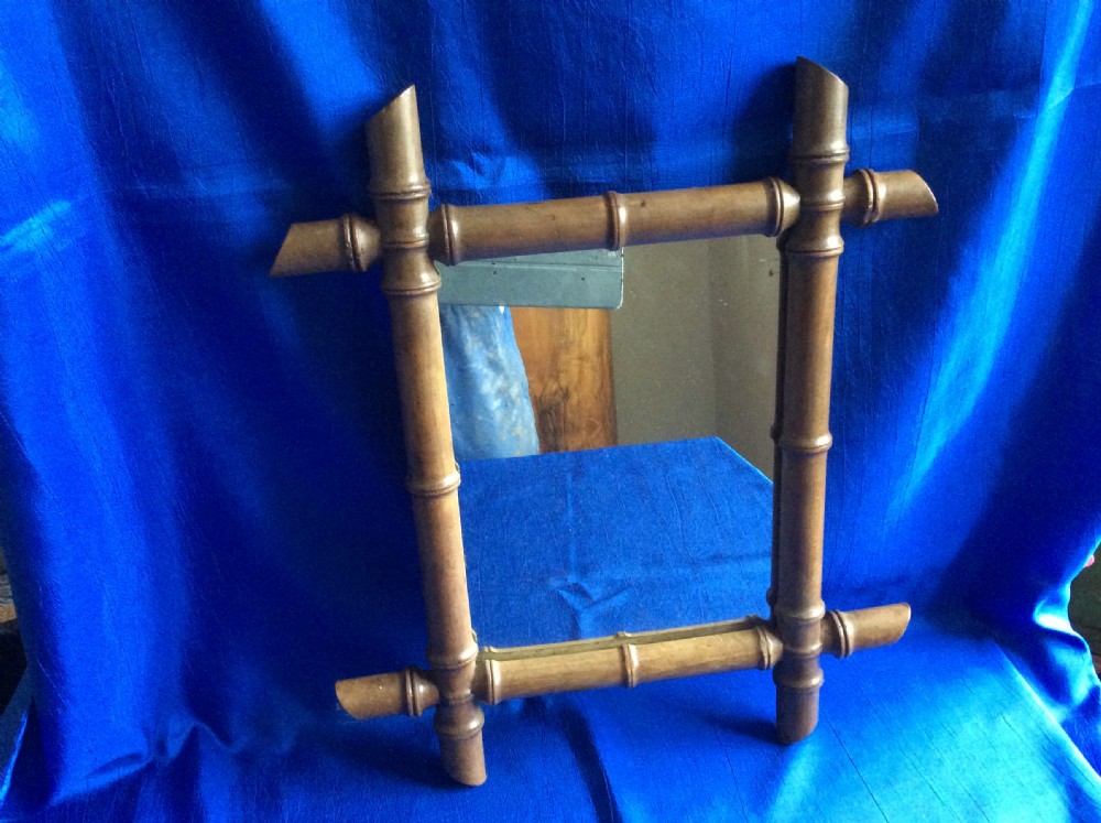 A small rectangular wall mirror surrounded by a carved timber frame crafted to resemble natural bamboo stalks with turned nodes. View II