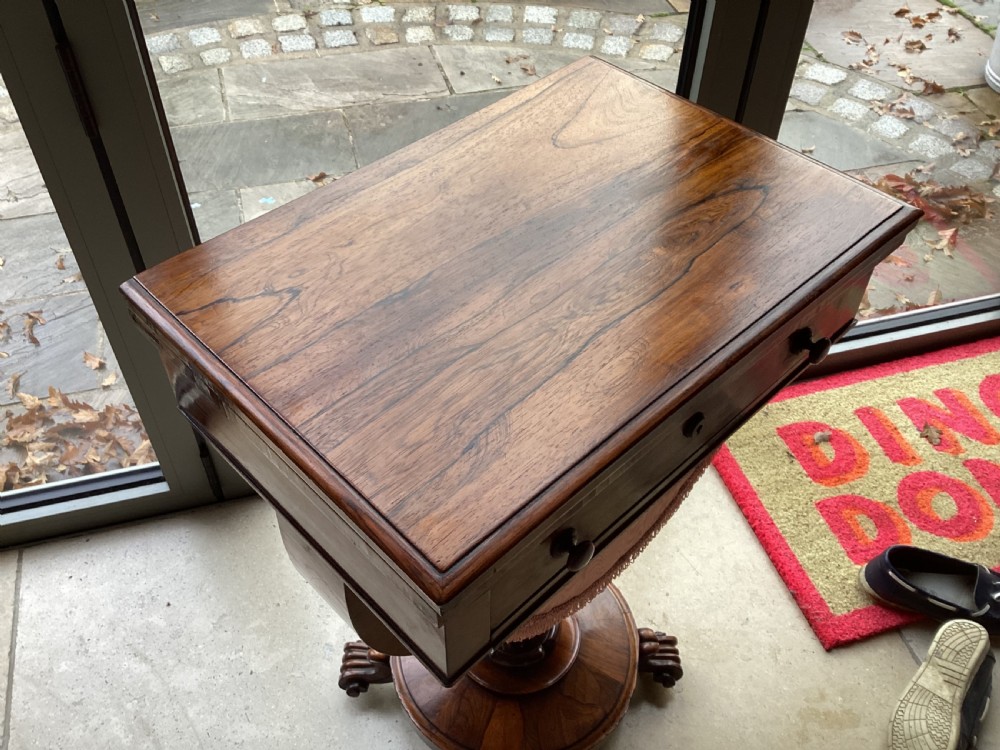 A 19th-century rosewood sewing table featuring a top drawer, a pink pleated silk work basket supported by a U-shaped frame, and a pedestal base with carved scroll feet. View III