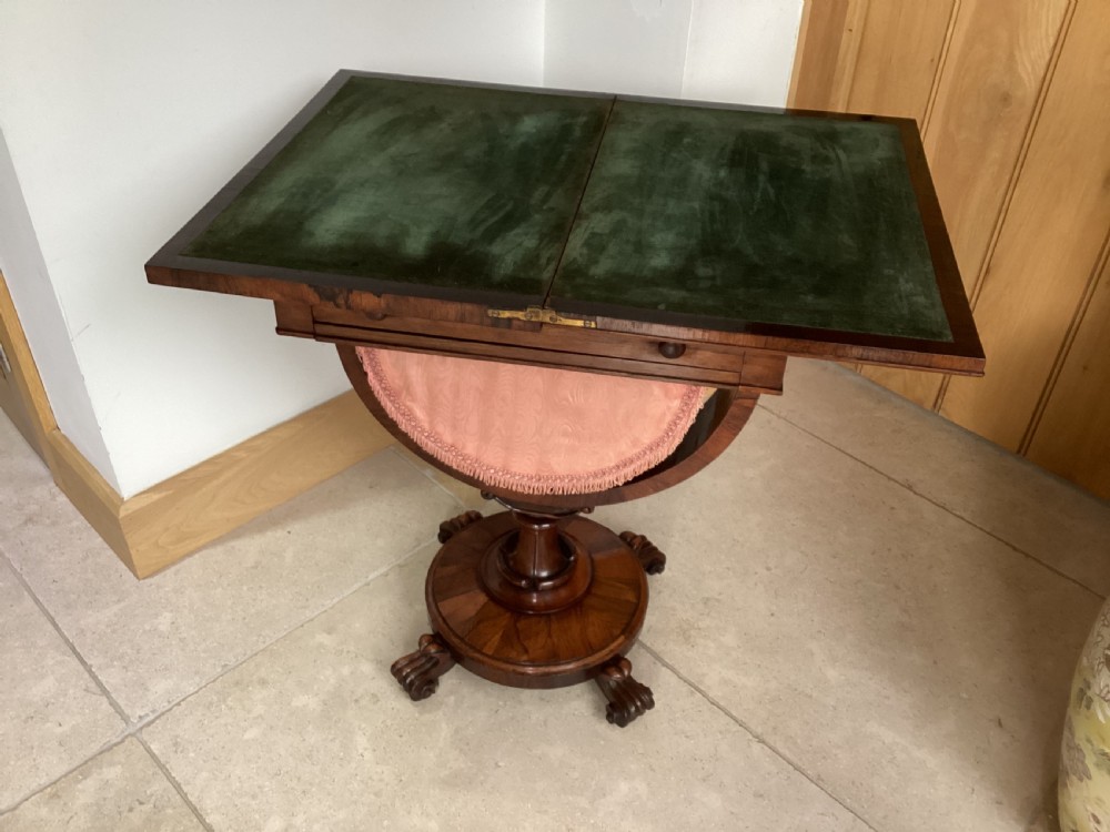 A 19th-century rosewood sewing table featuring a top drawer, a pink pleated silk work basket supported by a U-shaped frame, and a pedestal base with carved scroll feet. View XI