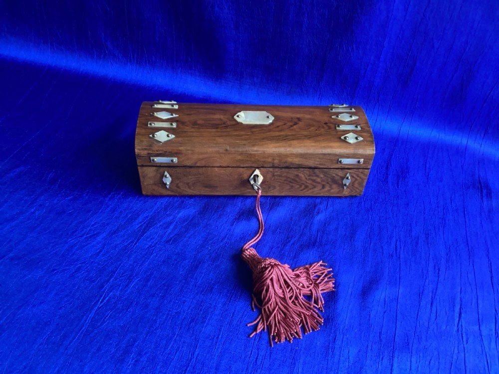 A Victorian rosewood glove box featuring a domed lid, inlaid bone diamond accents, a central escutcheon, and a key with a pink tassel. View II