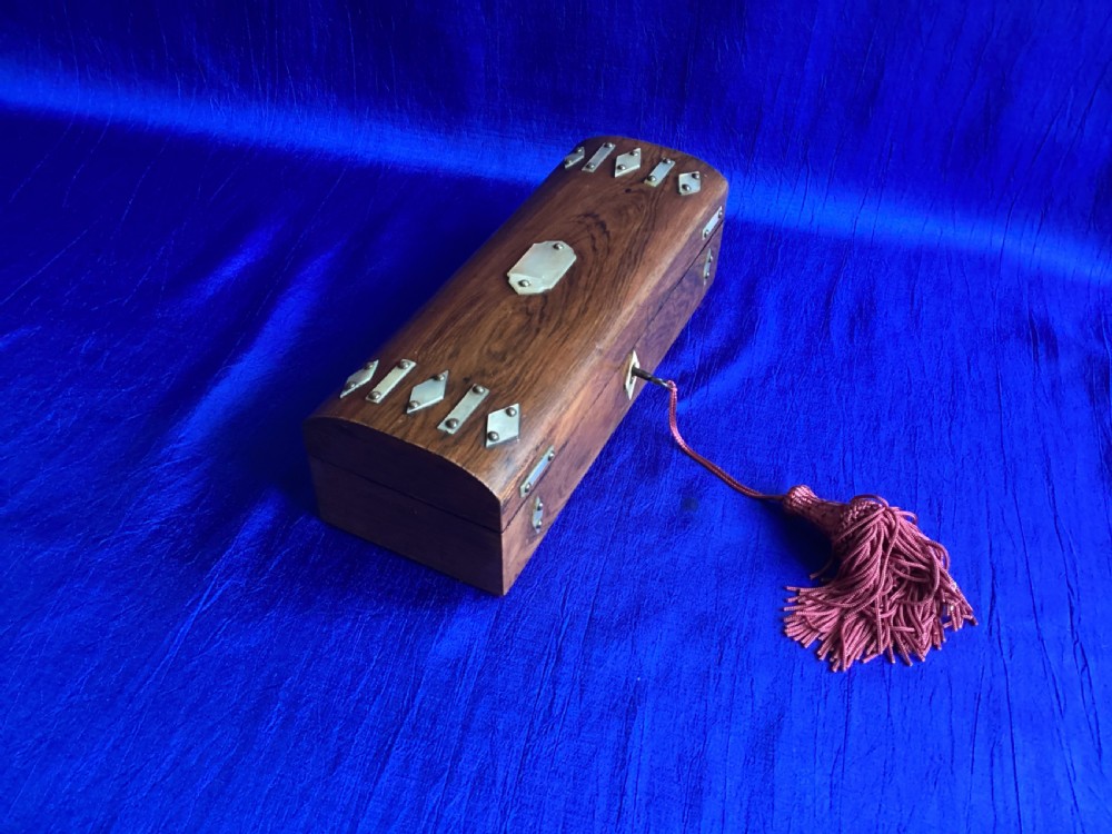 A Victorian rosewood glove box featuring a domed lid, inlaid bone diamond accents, a central escutcheon, and a key with a pink tassel. View III