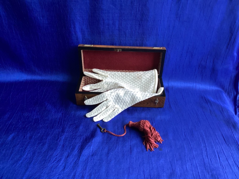 A Victorian rosewood glove box featuring a domed lid, inlaid bone diamond accents, a central escutcheon, and a key with a pink tassel. View VII