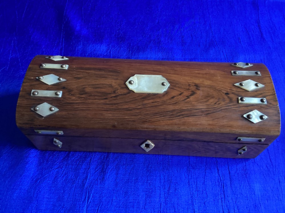 A Victorian rosewood glove box featuring a domed lid, inlaid bone diamond accents, a central escutcheon, and a key with a pink tassel. View IX