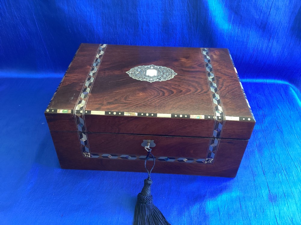 A dark rosewood rectangular writing slope featuring mother-of-pearl and abalone shell geometric inlaid borders and a central decorated cartouche.