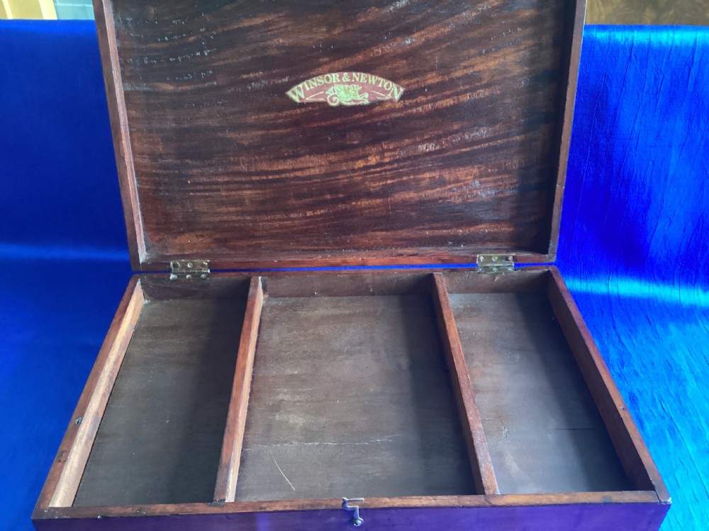 A rectangular Edwardian mahogany artist box featuring a hinged top lid, a lower pull-out drawer with a brass handle, and a brass hook latch on the front. View V