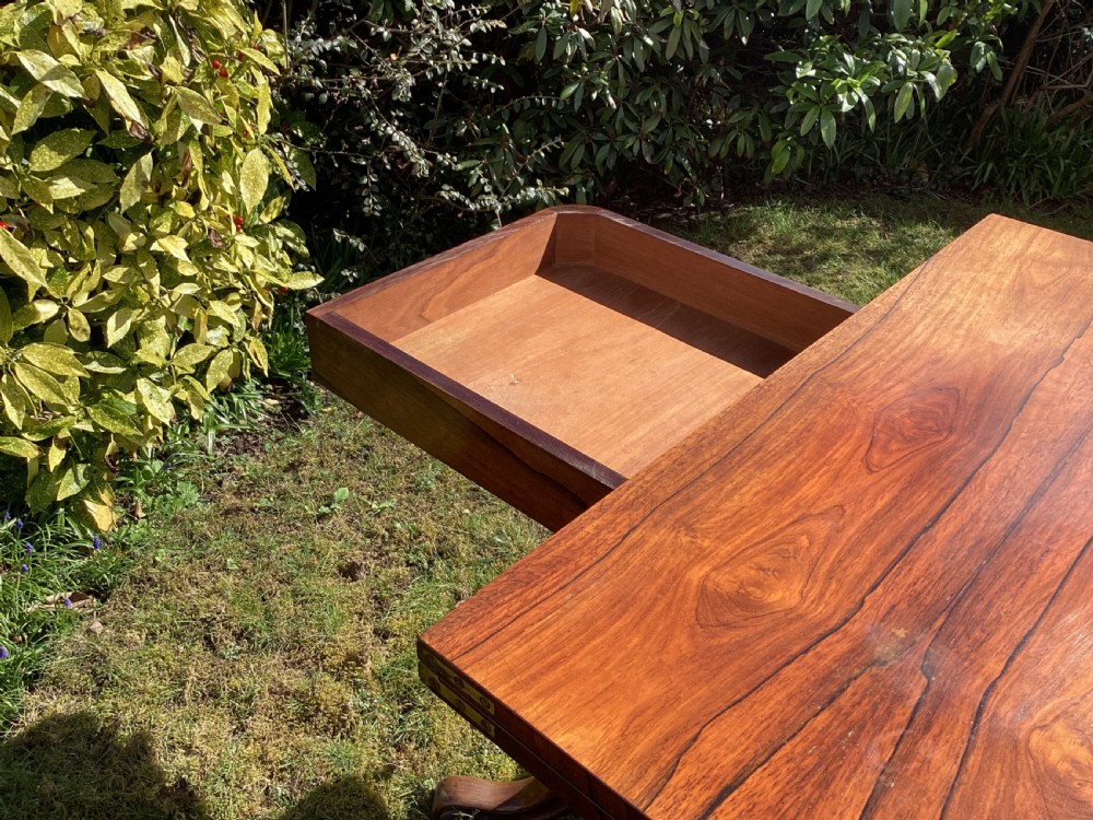 Victorian rosewood fold-over games table supported by a central turned pedestal column and four carved scroll feet. View VI