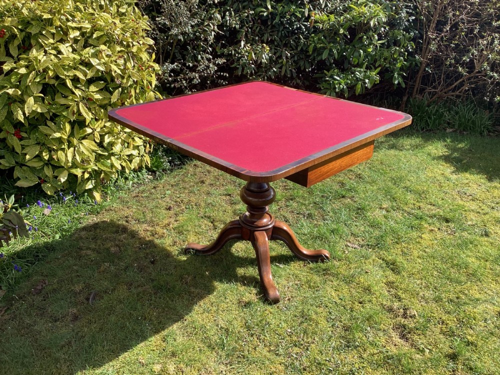 Victorian rosewood fold-over games table supported by a central turned pedestal column and four carved scroll feet. View VII