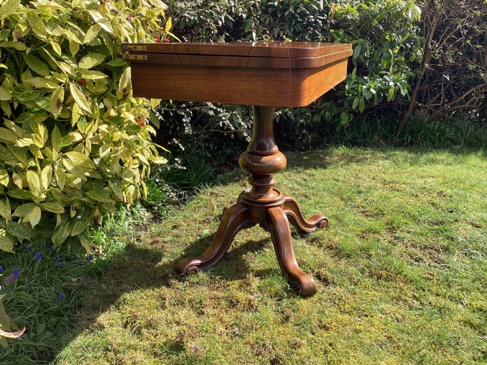 Victorian rosewood fold-over games table supported by a central turned pedestal column and four carved scroll feet. View VIII