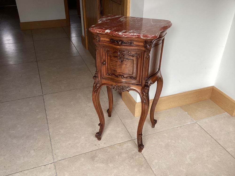 An antique French Rococo style carved walnut pot cupboard with a contoured red marble top and slender cabriole legs. View II